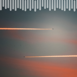 Two airplanes leave bright contrails across a pastel sunset sky, one higher than the other and angled in opposite directions.