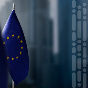 Primer plano de la bandera de la Unión Europea en un mástil, con un fondo azul y estrellas doradas cerca del borde izquierdo.