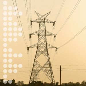 Transmission tower with power lines against a pale sky in a rural setting.