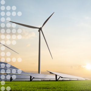Windkraftanlage und Solarmodule auf einer Wiese bei Sonnenuntergang als Symbol für erneuerbare Energien.