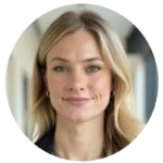 Portrait en buste d'une femme blonde souriante, vêtue d'un blazer foncé.