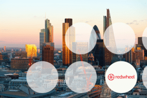 City skyline at sunset with large translucent circles overlaying the buildings; Redwheel branding visible in the lower-right corner.