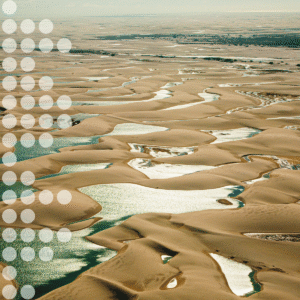 Vue aérienne de dunes de sable sillonnées de canaux sinueux aux eaux turquoise, dont le bord gauche est recouvert de cercles blancs translucides.